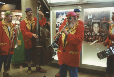 605866 Afbeelding van een groepje als clowns verklede staatmuzikanten in het winkelcentrum Hoog Catharijne te Utrecht.